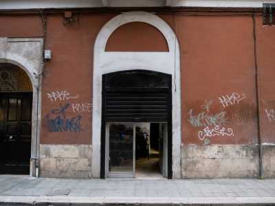 ...caratterizzato da una spoglia vetrina coperta per met� da una saracinesca nera